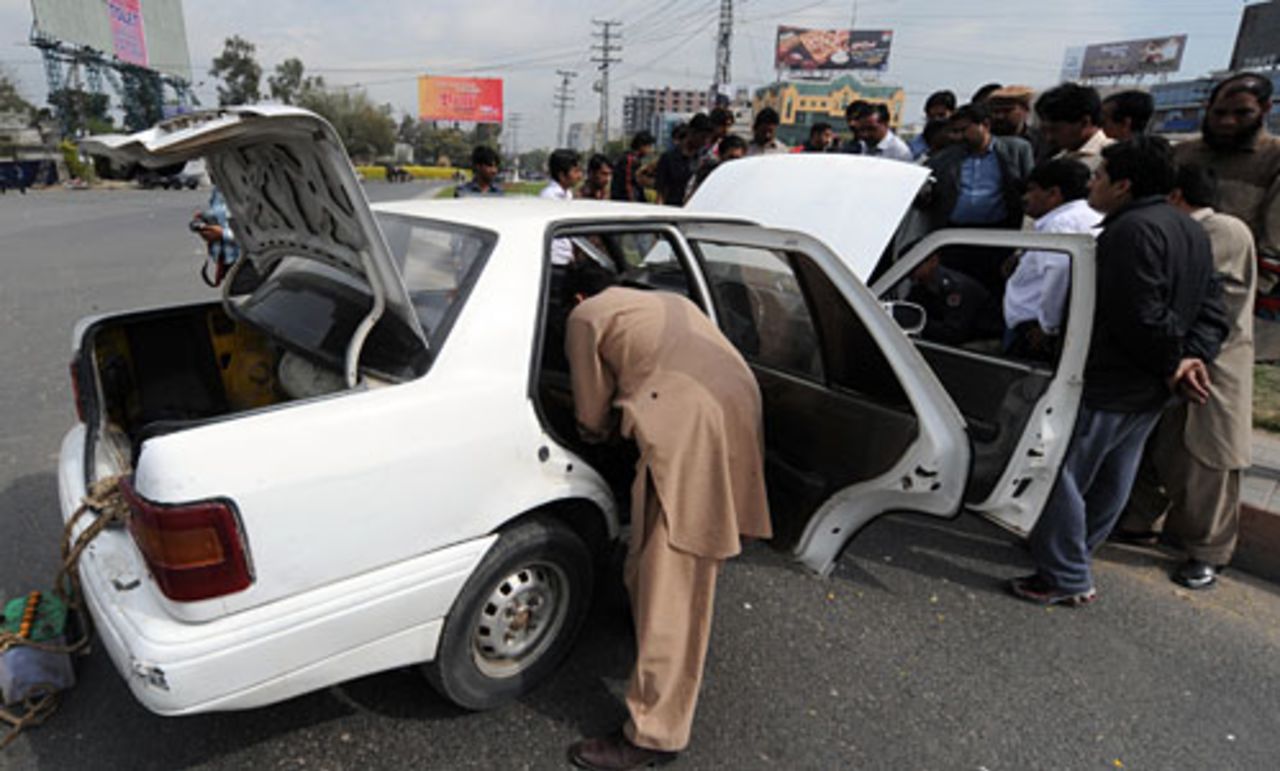 Officials inspect a car allegedly used by the terrorists during the firing, Lahore, March 3, 2009