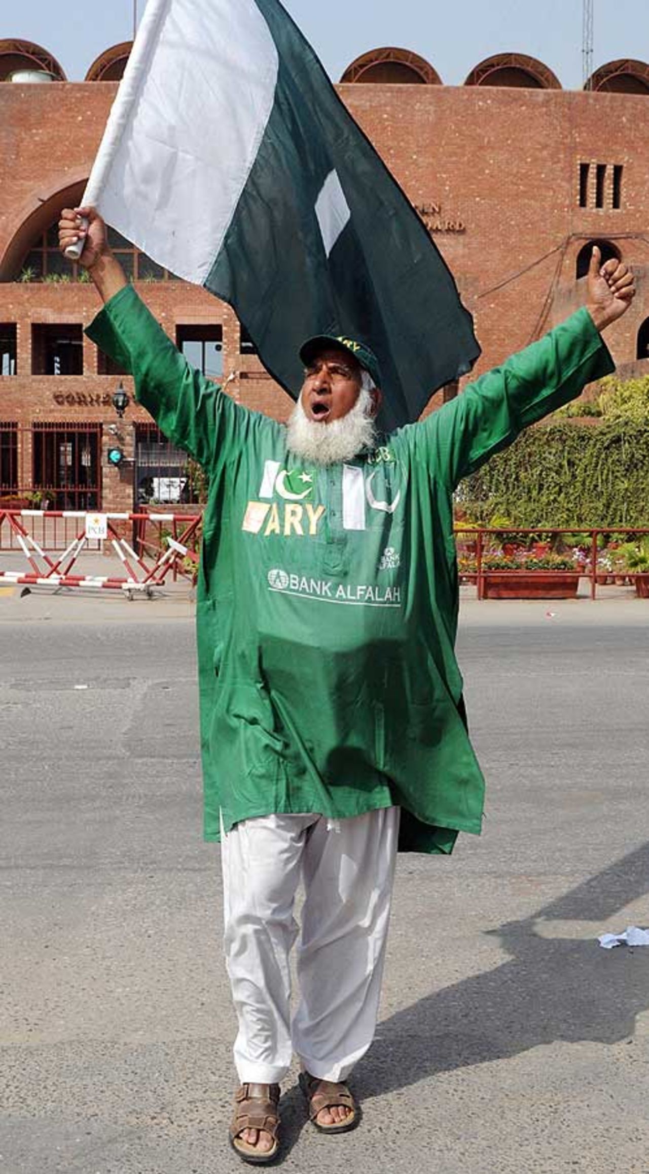 Sufi Abdul Jalil - <i>Chacha</i> Cricket - waves a national flag in front of the Gaddafi Stadium, Lahore, March 6, 2009