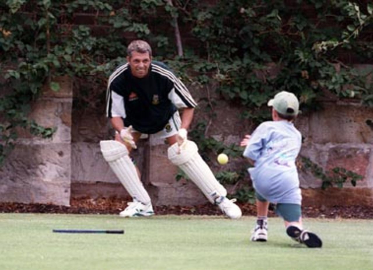 South African Wicket keeper Dave Richardson gets some practice with his eldest son Michael, during the South Africans' nets session at the SCG on New Year's Day, 1998.