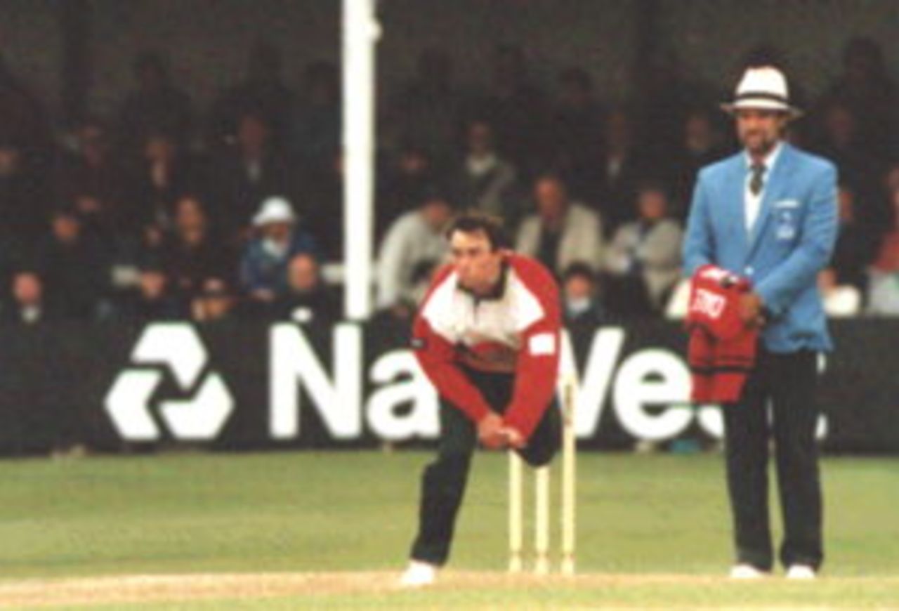 Adrian Dale bowling during a Sunday League match in Cardiff in         1996. Peter Willey is standing as umpire.