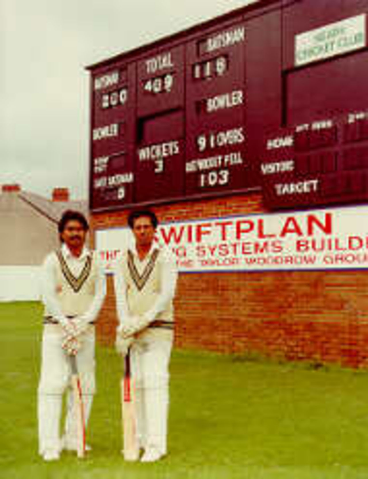 Javed Miandad and Younis Ahmed standing in front of the Neath scoreboard after their triple century partnership against the Australians in 1985