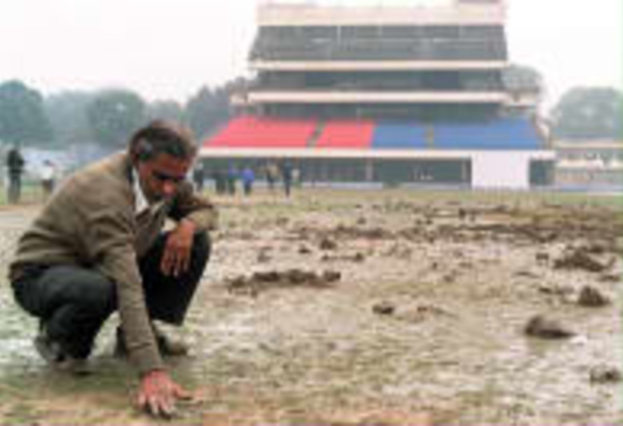 An Indian grounds inspector examines the damaged  pitch in Delhi. The wicket at the Ferozeshah Kotla Stadium in New Delhi was vandalised by militants protesting the tour by Pakistan, Jan 7 1999.