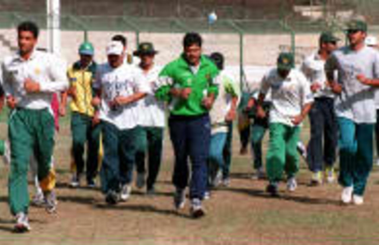 Pakistani cricket players run to take their exercise during a trial camp at the National Stadium to choose the team for the forthcoming Indian tour in Karachi 12 January 1998.