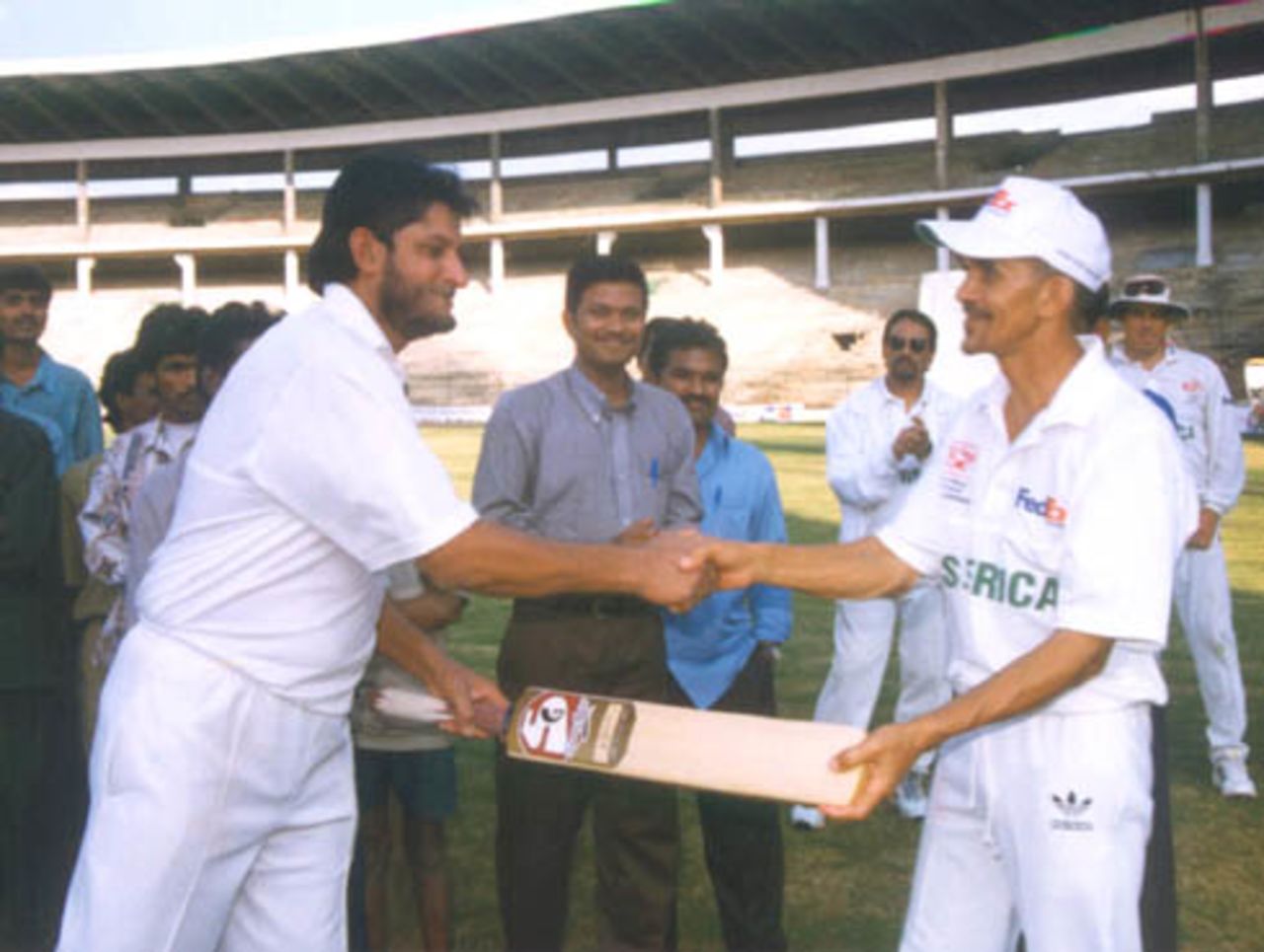 Sandeep Patil handing over the bat of friendship to O Henry SA captain