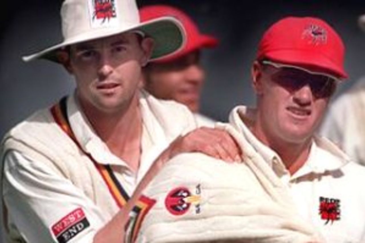 9 Dec 1999: Brad Young (centre) of South Australia is congratulated by team mate, Ben Johnson as South Australia leave the field after after bowling out Victoria for 169 runs in the Pura Milk Cup match between Victoria and South Australia, played at the Melbourne Cricket Ground, Melbourne, Australia. Young finished with five wickets