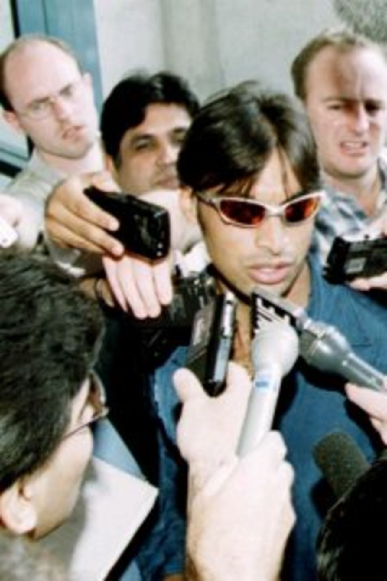 9 Jan 2000: Controversial fast bowler Shoaib Akhtar of Pakistan arrives at The Gabba Cricket ground amongst a chaotic press presence after the International Cricket Council overturned their decision to ban him indefinately from cricket for an illegal throwing action before the Carlton and United one day international against Australia at The Gabba, Brisbane, Australia.