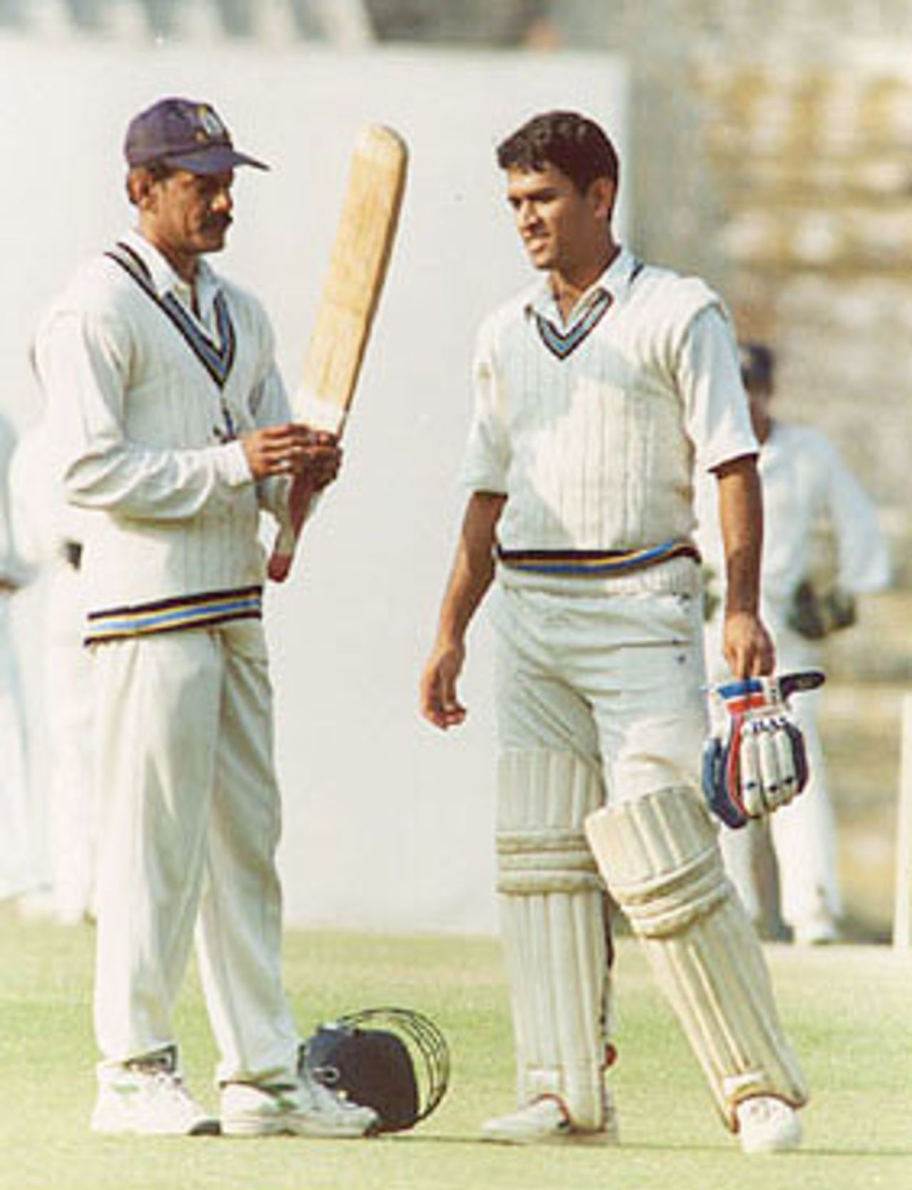 Utpal Chatterjee taking a look at MS Dhoni's bat in between the overs, Ranji Trophy East Zone League, 2000/01, Bengal v Bihar, Eden Gardens, Calcutta, 03-06 January 2001.