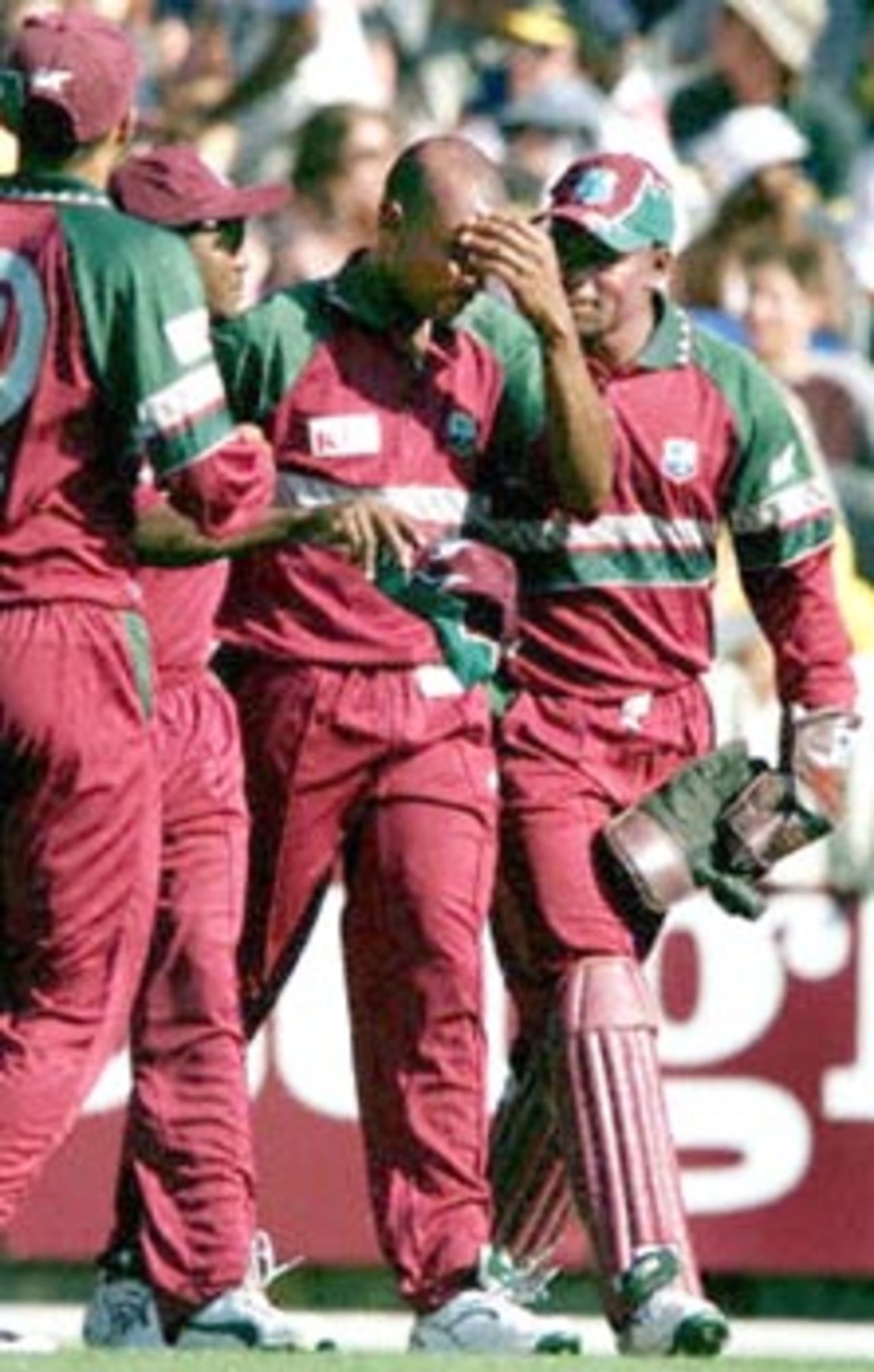 West Indian fieldsman Laurie Williams (2/R) is comforted by wicketkeeper Ridley Jacobs (R), Brian Lara (2/L) and captain Jimmy Adams (L) after hurting himself trying to take a catch looks on in their one day clash against Australia at the MCG in Melbourne 11 January 2000. Australia scored 267-6 off their 50 overs with the West Indies about to start their innings.