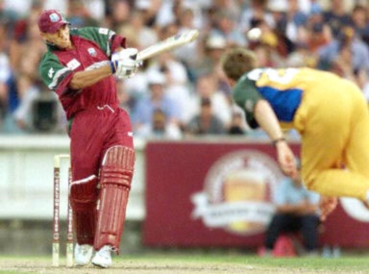 West Indies batsman Ricardo Powell (L) hits out against the Australian bowling of Ian Harvey (R) in their match at the MCG in Melbourne, 11 January 2000. Australia scored 267-6 off their 50 overs and then restricted the West Indies to 193-7 from their 50 overs to go one up in the tri-nations series which also includes Zimbabwe