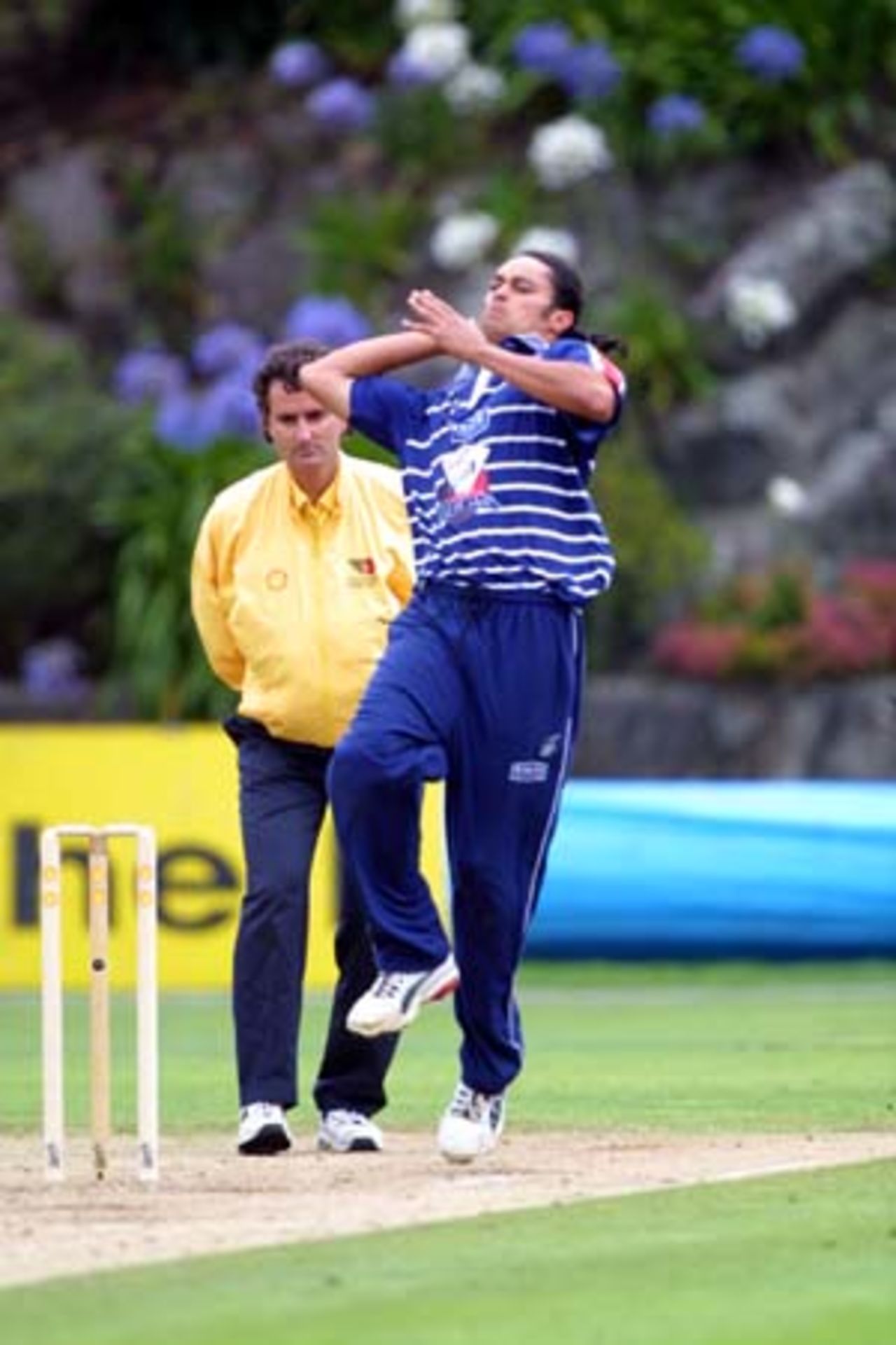 Auckland all-rounder Tama Canning at the height of his run-up ready to deliver with umpire Billy Bowden looking on, Shell Cup: Auckland v Central Districts at Eden Park Outer Oval, Auckland, 16 January 2001