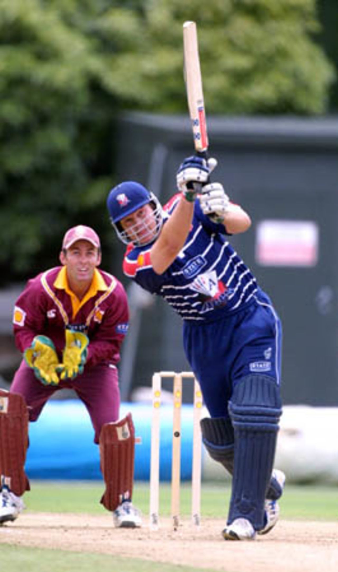Auckland opening batsman Llorne Howell lofts a ball down the ground during his innings of 67 as Northern Districts wicket-keeper Robbie Hart looks on, Shell Cup: Auckland v Northern Districts at Eden Park Outer Oval, Auckland, 18 January 2001