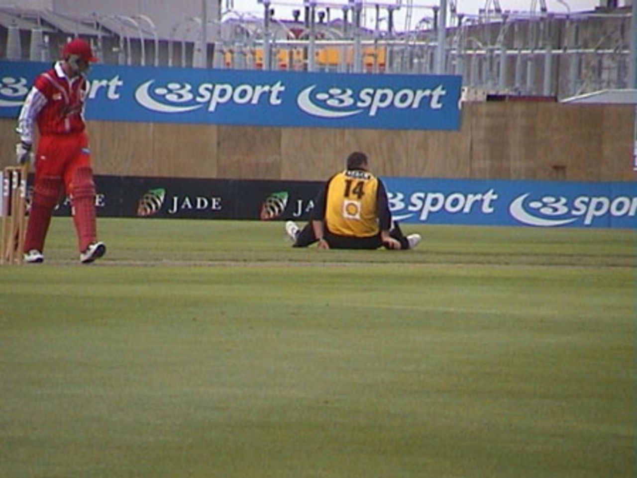 Wellington bowler Matthew Walker stretches in between overs while Canterbury batsman Gary Stead looks on, Shell Cup: Canterbury v Wellington at Jade Stadium, Christchurch, 18 January 2001