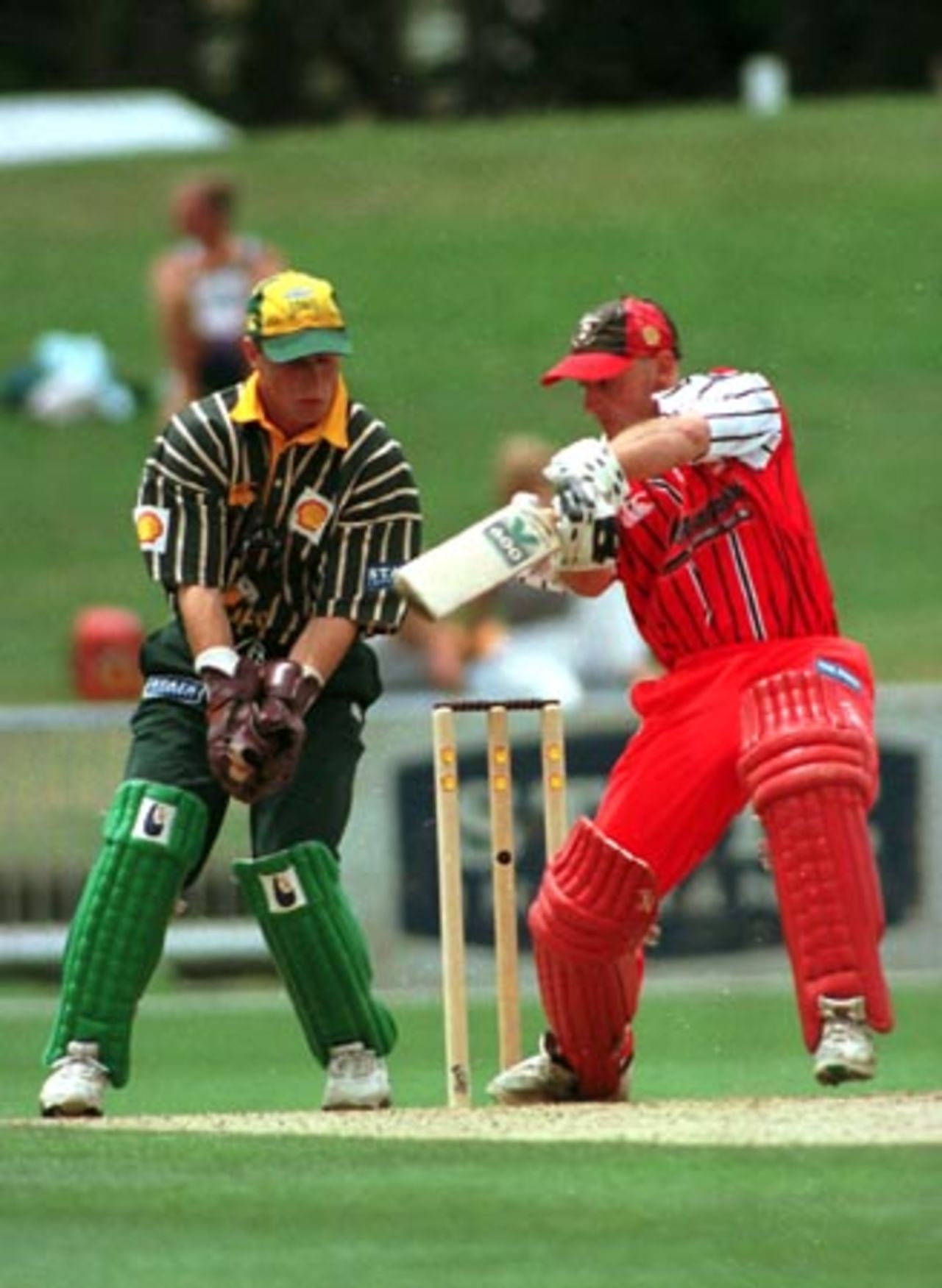 Canterbury wicket-keeper/batsman Gareth Hopkins forces off the back foot through point during his innings of 7 as Central Districts wicket-keeper Bevan Griggs looks on. 1st Shell Cup Final: Central Districts v Canterbury at McLean Park, Napier, 24 January 2001.