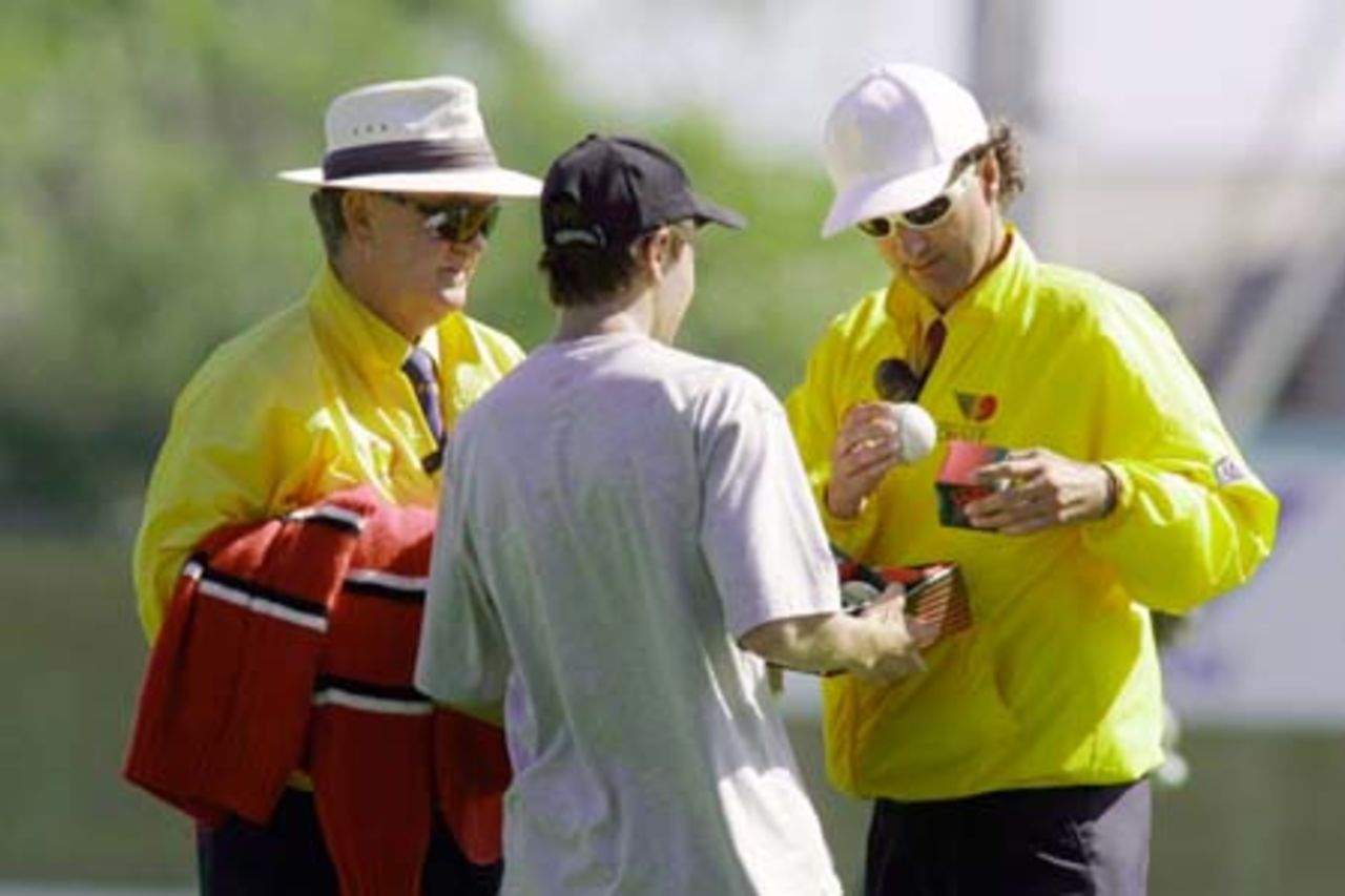 Umpire Billy Bowden inspects a replacement ball after Central Districts batsman Craig Spearman lost the previous ball by depositing high over midwicket, into a construction site for a new stand to replace the old embankment previous situated there. Fellow umpire Doug Cowie looks on while a young assistant holds a tray of potential replacement balls. 3rd Shell Cup Final: Canterbury v Central Districts at Jade Stadium, Christchurch, 28 January 2001.