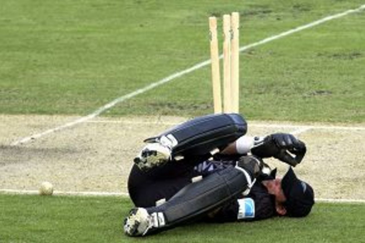 8 Jan 2002: Adam Parore of New Zealand falls to the ground after being hit in the throat by the ball after successfully running out Darren Lehmann of Australia A during the Australia A versus New Zealand one day cricket match played at the Gabba in Brisbane, Australia.