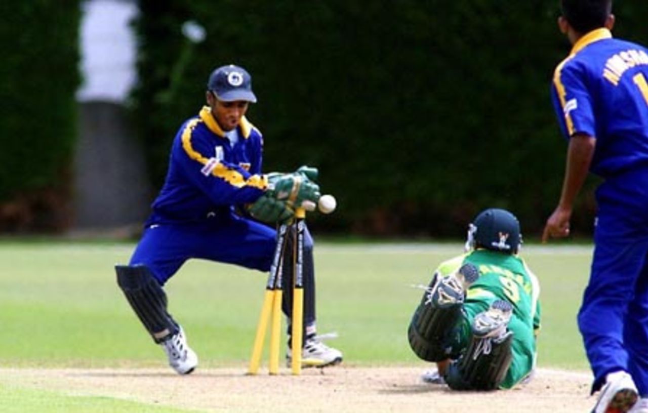 Sri Lanka Under-19 wicket-keeper Charith Sylvester runs out Pakistan Under-19 batsman Kamran Sajid, despite a despairing dive for the crease, for 31. Fielder Dhammika Niroshan (right) looks on. ICC Under-19 World Cup Super League Group 1: Pakistan Under-19s v Sri Lanka Under-19s at Lincoln No. 3, Lincoln, 27 January 2002.