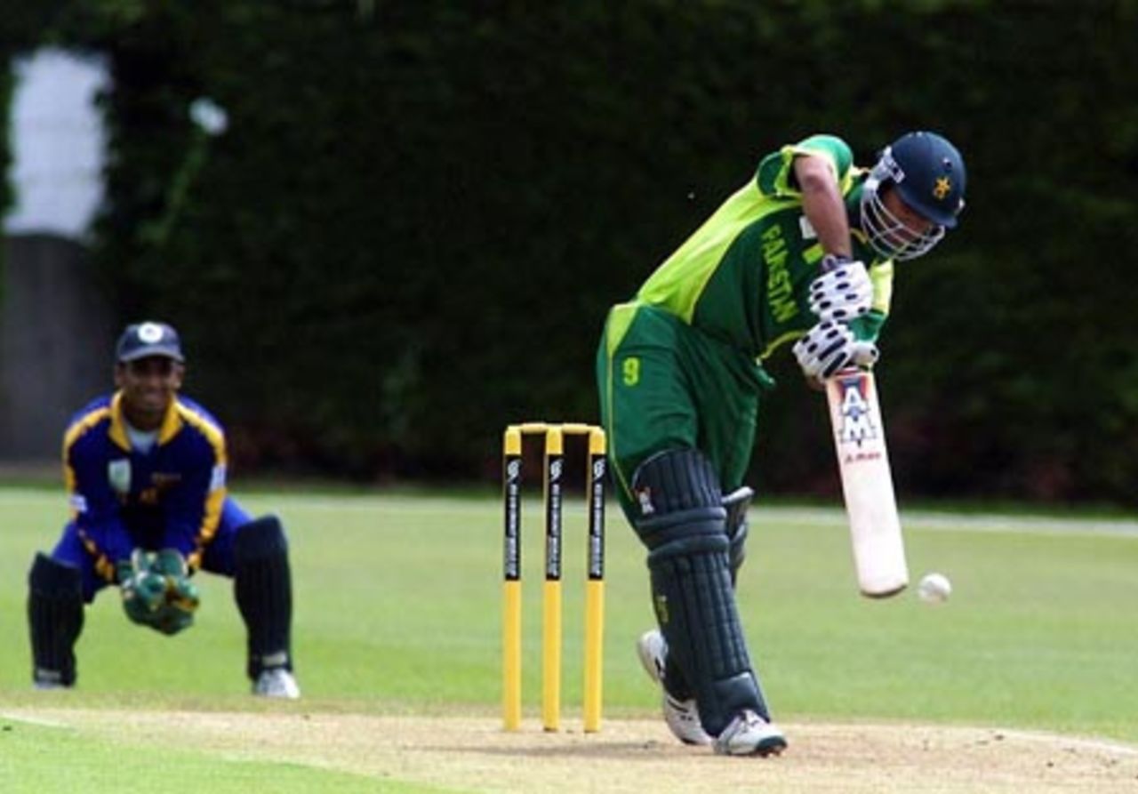 Pakistan Under-19 batsman Kamran Sajid drives a delivery down the ground to the boundary during his innings of 31. Sri Lanka Under-19 wicket-keeper Charith Sylvester looks on. ICC Under-19 World Cup Super League Group 1: Pakistan Under-19s v Sri Lanka Under-19s at Lincoln No. 3, Lincoln, 27 January 2002.