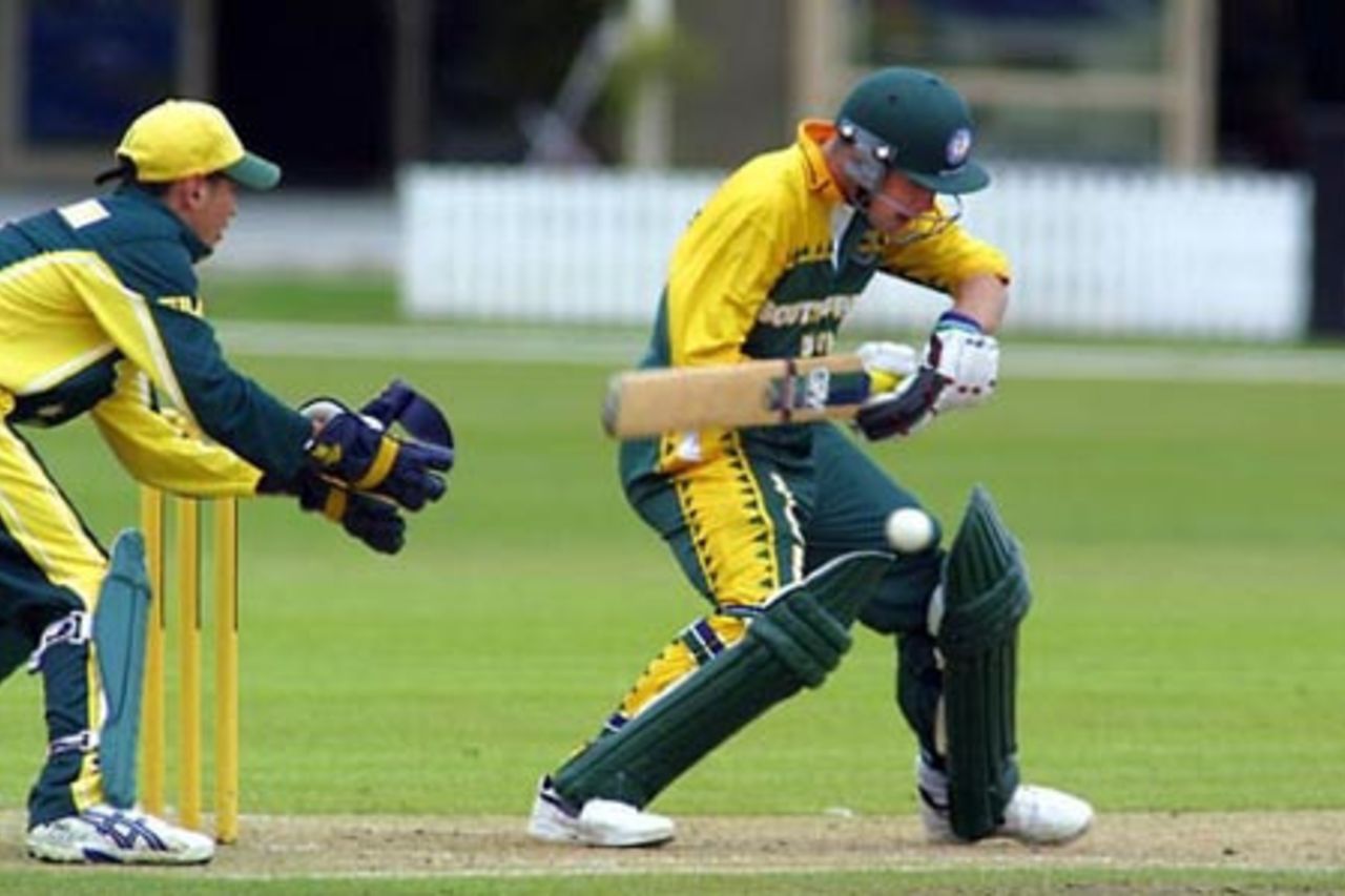 South Africa Under-19 batsman Stephen Cook shapes to cut a delivery during his innings of 48. Australia Under-19 wicket-keeper Adam Crosthwaite looks on. ICC Under-19 World Cup Super League Group 2: Australia Under-19s v South Africa Under-19s at Bert Sutcliffe Oval, Lincoln, 28 January 2002.