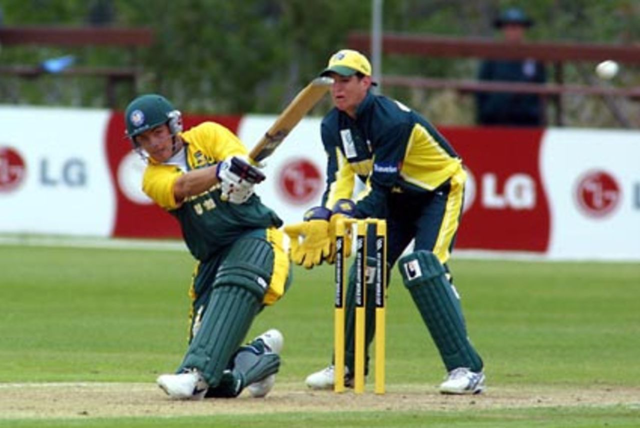 South Africa Under-19 batsman Stephen Cook swings a delivery through square leg to the boundary during his innings of 48. Australia Under-19 wicket-keeper Adam Crosthwaite looks on. ICC Under-19 World Cup Super League Group 2: Australia Under-19s v South Africa Under-19s at Bert Sutcliffe Oval, Lincoln, 28 January 2002.