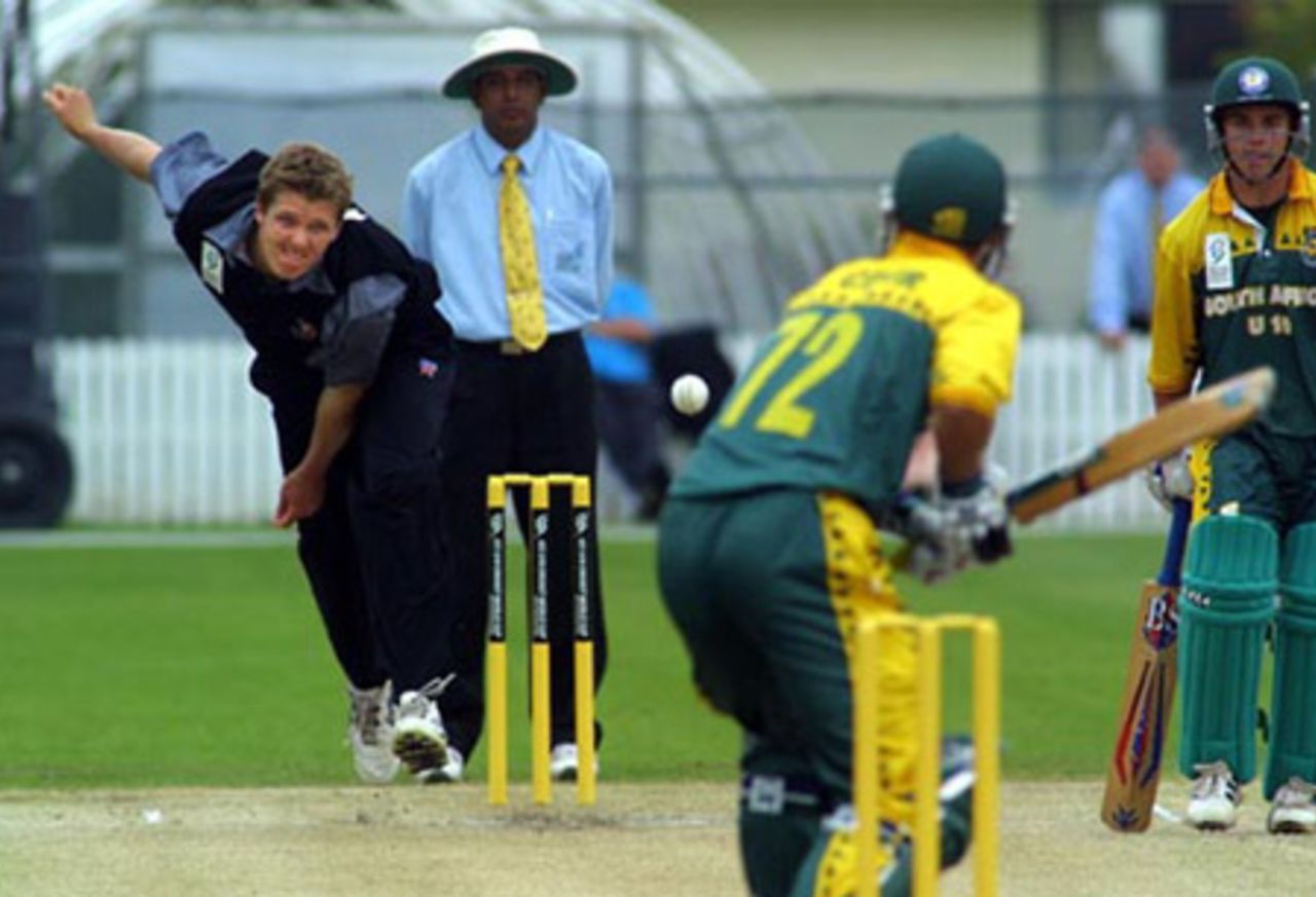 New Zealand Under-19 batsman Michael Bates delivers a ball to South Africa Under-19 batsman Stephen Cook during his spell of 0-28 from 10 overs. Umpire Asoka de Silva from Sri Lanka and batsman Chad Baxter look on. ICC Under-19 World Cup Super League Group 2: New Zealand Under-19s v South Africa Under-19s at Lincoln Green, Lincoln, 30 January 2002.
