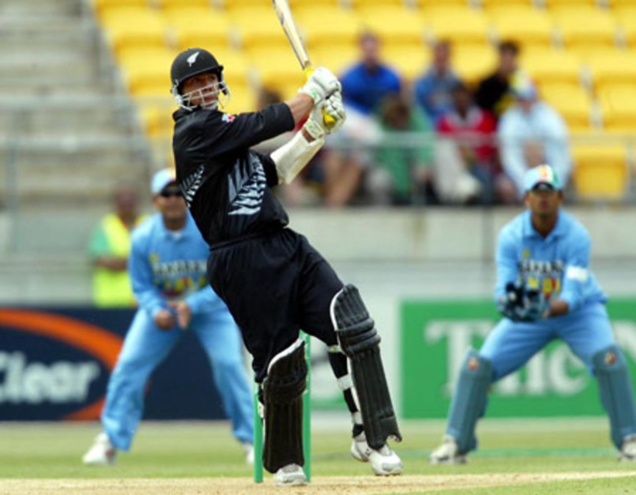 New Zealand batsman Andre Adams pulls a delivery through midwicket during his innings of 35. Indian slip fielder Virender Sehwag (left) and wicket-keeper Rahul Dravid look on in the background. 5th ODI: New Zealand v India at Westpac Stadium, Wellington, 8 January 2003.
