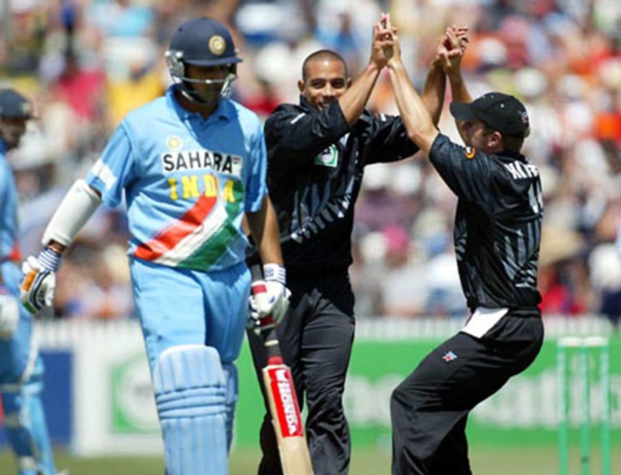 New Zealand bowler Andre Adams (centre) and team-mate Paul Hitchcock celebrate the dismissal of Indian batsman Mohammad Kaif (left), caught by wicket-keeper Brendon McCullum for 0. 7th ODI: New Zealand v India at Westpac Park, Hamilton, 14 January 2003.