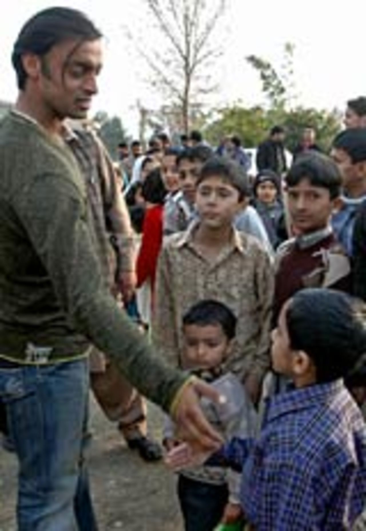 Shoaib Akhtar is greeted by young cricketers during a visit to the Diamond Cricket Club in Islamabad, January 31 2005