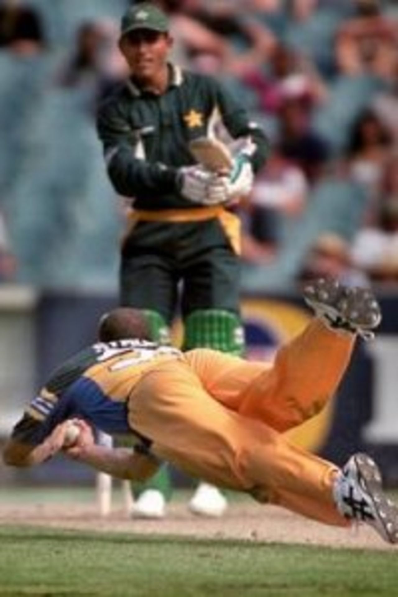 2 Feb 2000: Australian pace bowler Andrew Symonds dives to take a caught and bowled chance off Pakistan batsman Abdur Razzaq during the first final of the one day international between Australia and Pakistan played at the MCG, Melbourne, Australia. The catch was deemed not out due to doubt over whether or not it bounced.