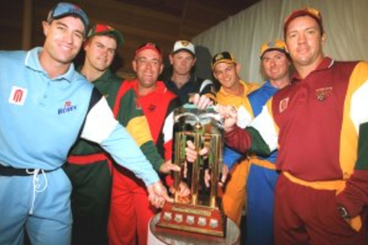 5 Oct 1999: The captains of the Mercantile Mutual cup teams from (L-R) Michael Bevan of New South Wales Blues, Jamie Cox of Tasmanian Tigers, Darren Lehmann of Southern Redbacks, Paul Reiffel of Victorian Bushrangers, Adam Gilchrist of Western Warriors, Rod Tucker of Canberra Comets and Stuart Law of Queensland Bulls huddle around the Mercantile Mutual trophy at the launch of the 1999/2000 Mercantile Mutual Cup season at North Sydney Oval, Sydney, Australia.