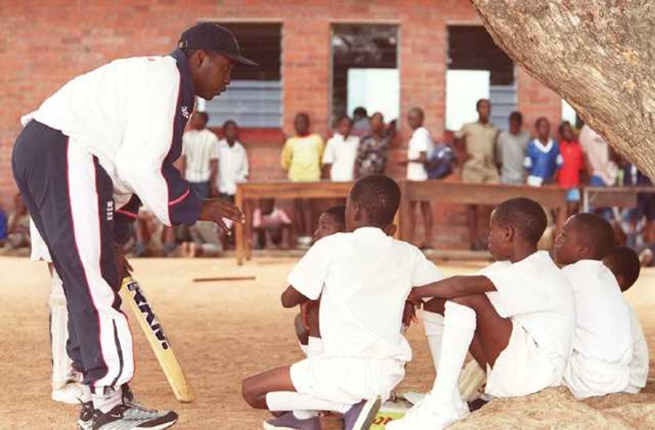 Mark Alleyne talks to youngsters at Chipembere Primary School, Highfield, Harare during a coaching session organized to mark the sponsorship of schools cricket in Zimbabwe by CricInfo