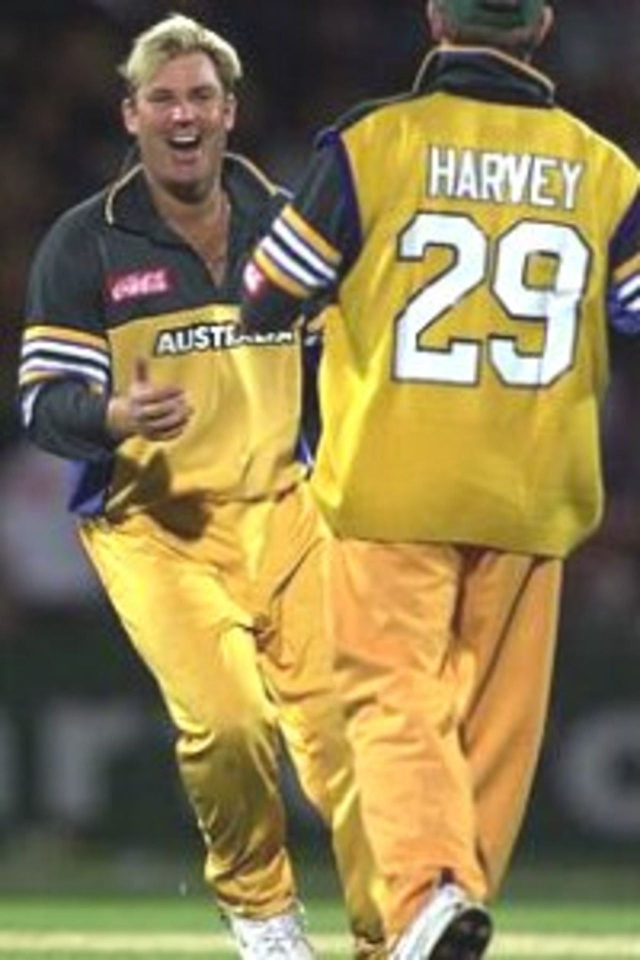 Shane Warne of Australia rushes to congratulate Ian Harvey (right) who caught Craig McMillan of New Zealand off Warne's bowling, during the third one day international between New Zealand and Australia at Carisbrook, Dunedin, New Zealand.