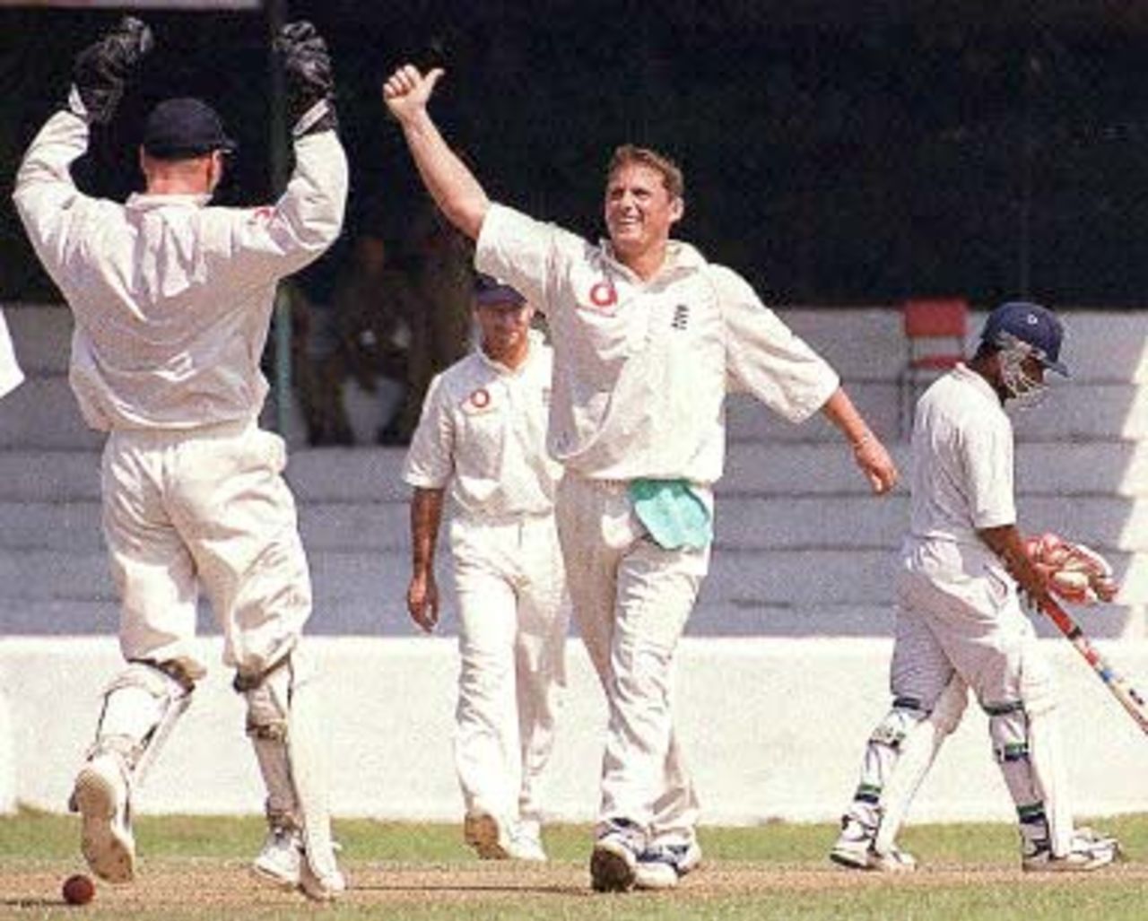 England bowler Darren Gough (C) celebrates 06 February 2001 with wicket keeper Paul Nixon (L - back to camera) and England skipper Nasser Hussain (partly covered) as he takes the wicket of Sri Lankan batsman Predeep Hewage (not in picture). England opened their tour off Sri lanka with a two-day match against a Sri Lankan Colts team. Batsman at non-strikers end is Malintha Perera.
