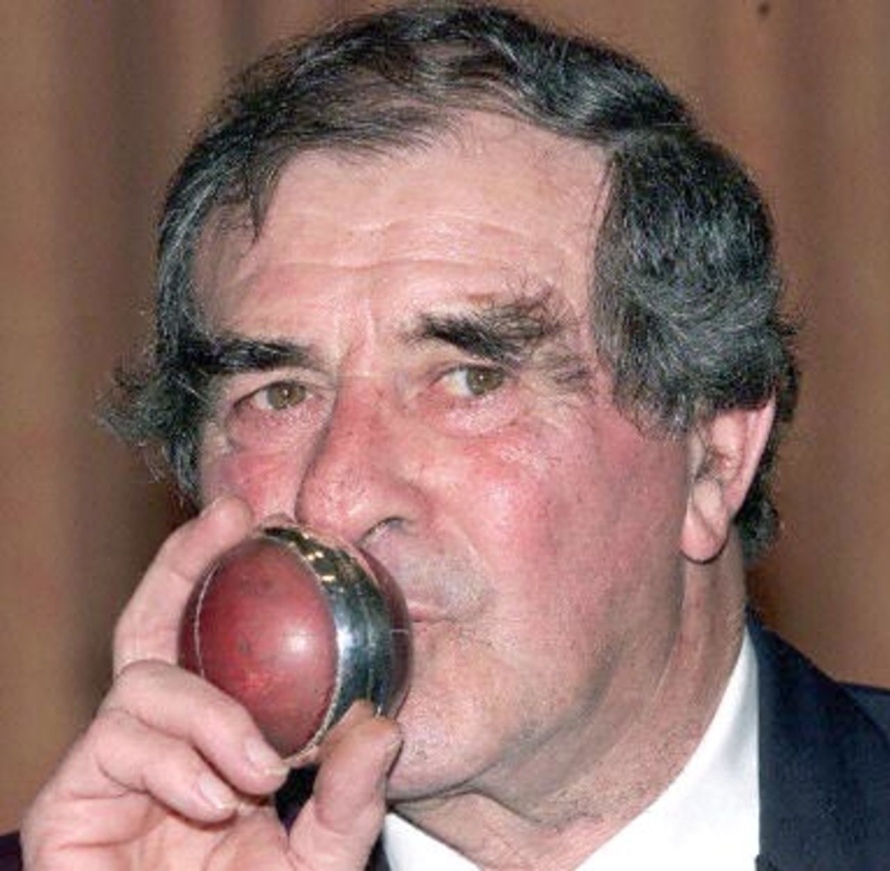 English cricket legend Fred Trueman tosses the cricket ball that he achieved his three hundreth test wicket against the West Indies in 1963, 06 February 2001, at the Grosvenor House in London. Trueman is guest of honour at his 70th birthday, where all his cricket possessions are to be auctioned.