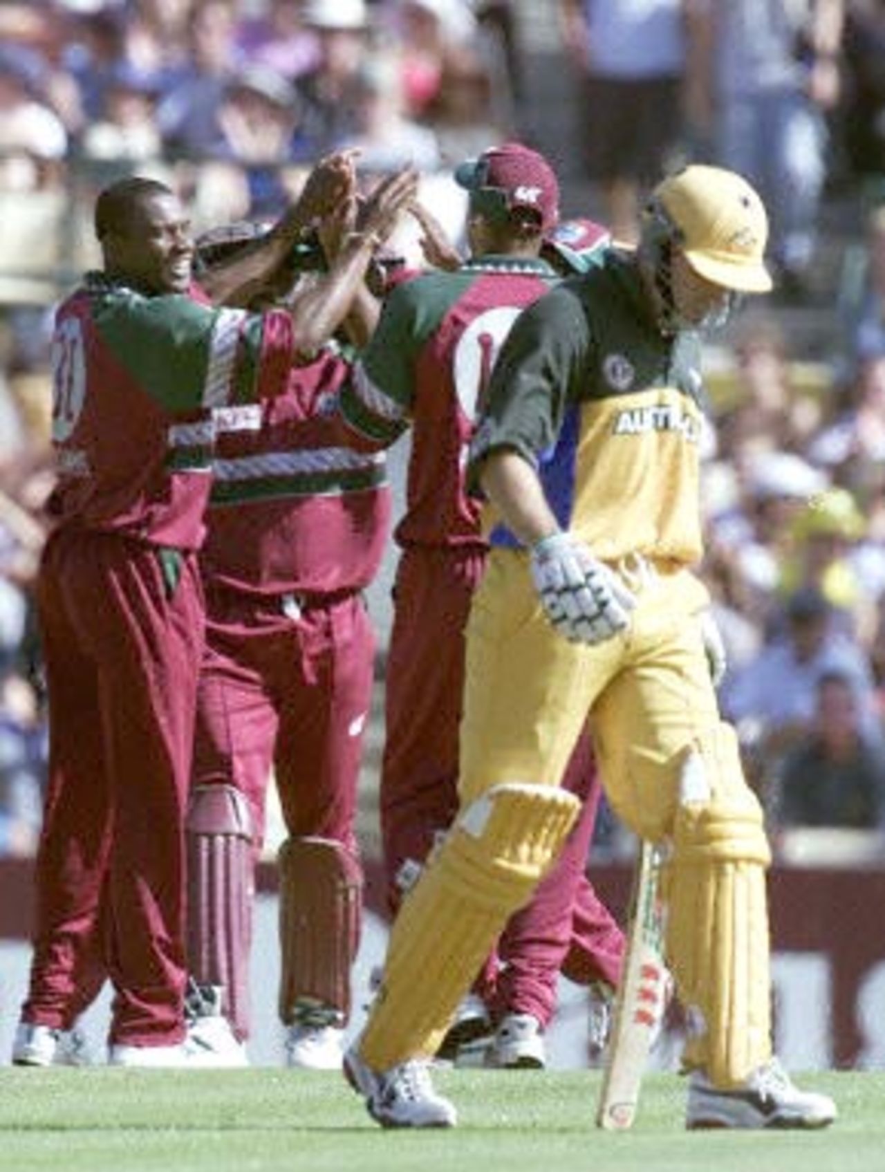 Australia's Michael Bevan (R) walks after being caught by West Indies wicket-keeper Ridley Jacobs during the first cricket Final between Australia and The West Indies in Sydney 07 February 2001. Bevan made 23 runs before being caught off the bowling of Laurie Williams.
