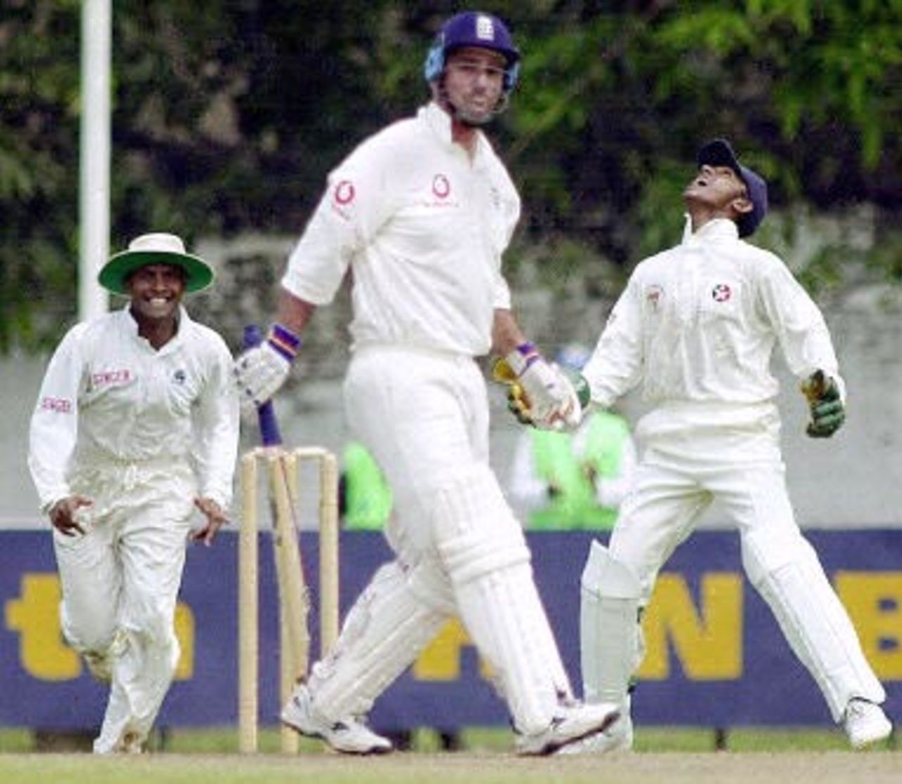 England batsman Graham Thorpe (C) prepares to leave the crease 08 February 2001 as Sri Lankan wicketkeeper Prasanna Jayawardena (R) celebrates his catch with fielder Hasha Thilakeratna (L) during a four-day match against a Sri Lanka Board President's XI held in Colombo. England will officially open their tour with a 22 February Test match.
