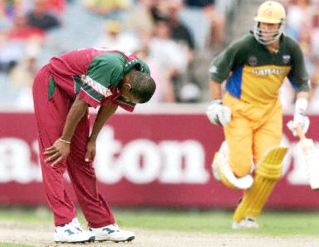 West Indian bowler Laurie Williams (L) looks at the ground in despair as Australian batsman Michael Bevan (R) plunders the bowling during the second one-day final against the West Indies at the MCG in Melbourne 09 February 2001. Australia amassed the huge total of 338-6 with Mark Waugh topscoring with 173.