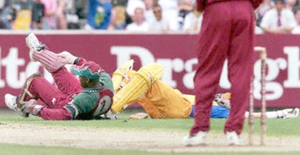 West Indian wicketkeeper Ridley Jacobs (L) and Australian batsman Mark Waugh (R) lie on the ground after a collision during the second one-day final against the West Indies at the MCG in Melbourne 09 February 2001. Australia amassed the huge total of 338-6 with Mark Waugh topscoring with 173.