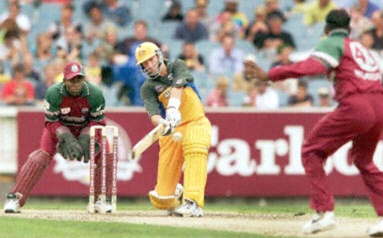 Australian batsman Mark Waugh (C) smashes a ball to the boundary from West Indian bowler Mahendra Nagamootoo (R) as wicketkeeper Ridley Jacobs looks on as Waugh scores a century during the second one-day final against the West Indies at the MCG in Melbourne 09 February 2001. Australia amassed the huge total of 338-6 with Waugh topscoring with 173.