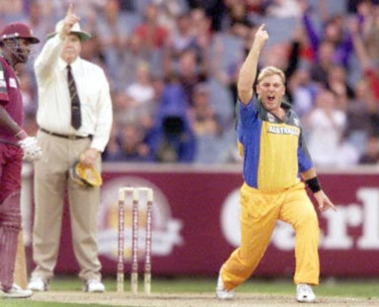The umpire (C) raises his finger as Australian bowler Shane Warne (R) celebrates trapping West Indian batsman Ricardo Powell LBW as Wavell Hinds (L) looks on during the 2nd one-day final against the West Indies at the MCG in Melbourne 09 February 2001. Australia amassed the huge total of 338-6 with Mark Waugh topscoring with 173 and in reply the West Indies are 144-3 after 22 overs.