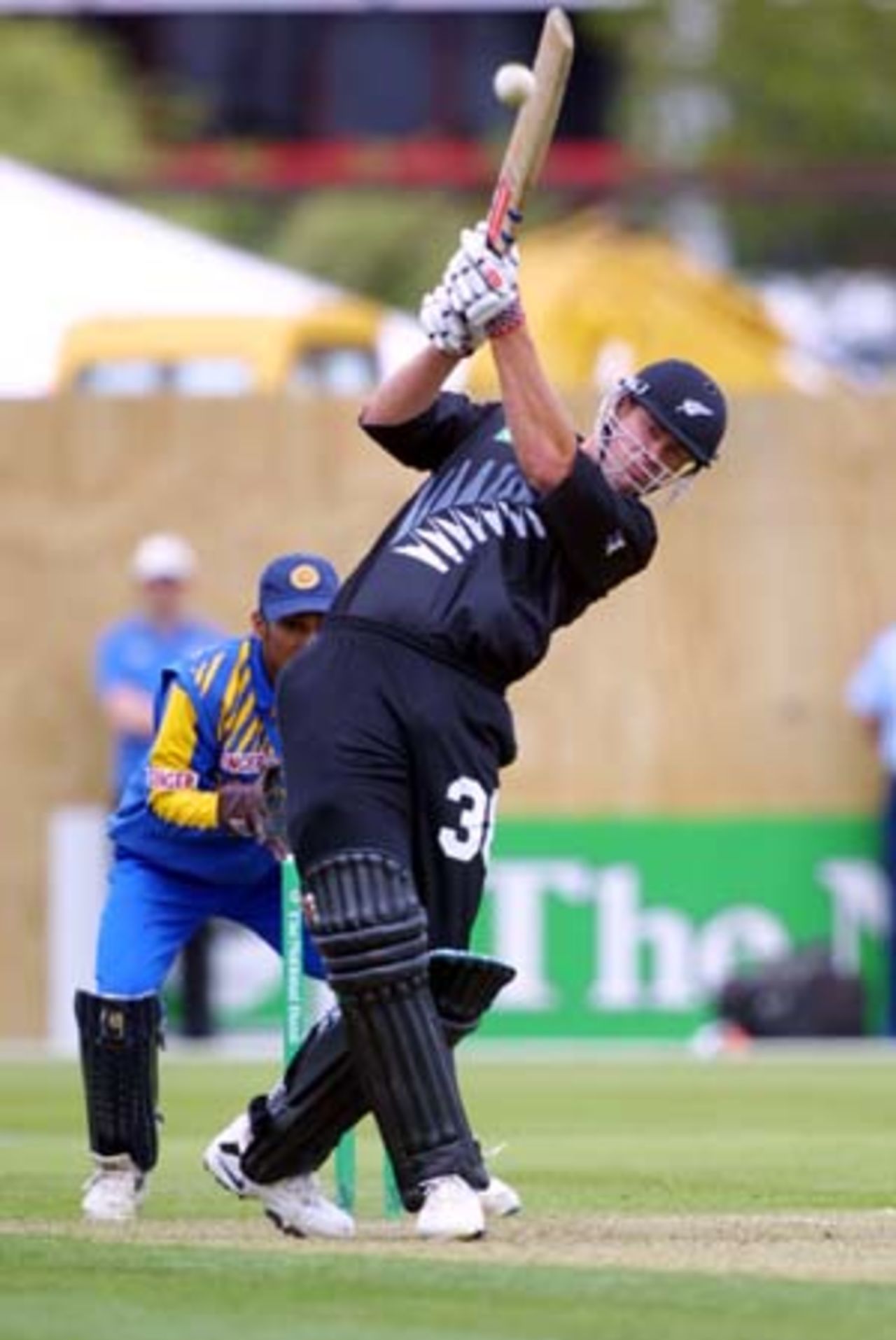 New Zealand batsman Jacob Oram lofts a ball from Sri Lankan off spinner Kumar Dharmasena over long on for six. Oram struck four sixes in his innings of 59. Wicket-keeper Kumar Sangakkara (obscured) looks on. 5th One-Day International: New Zealand v Sri Lanka at Jade Stadium, Christchurch, 11 February 2001.