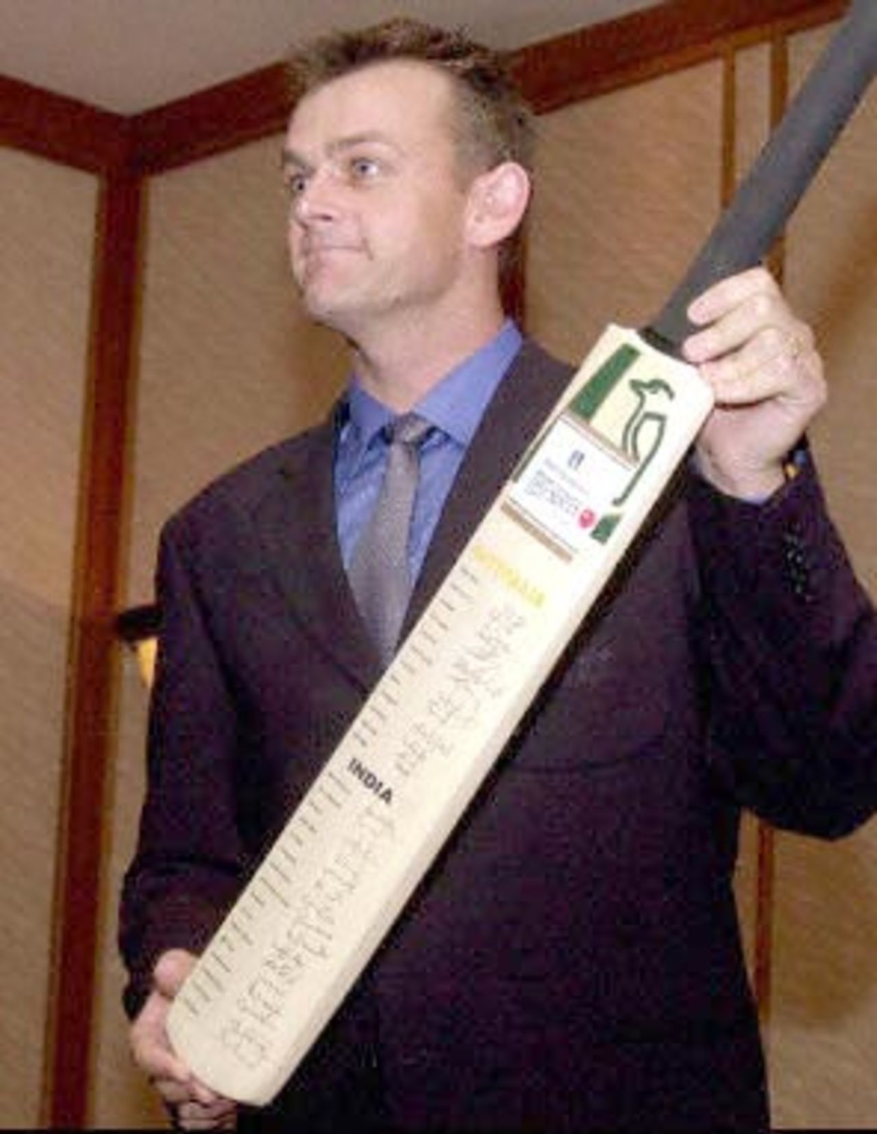 Australian vice-captain Adam Gilcrist shows off the bat autographed by Indian and Australian cricketers during a press conference, 14 February 2001, on arrival at a press conference in Bombay. The bat is to be auctioned during the series of matches to be played across the country and the proceeds will be given to the victims of the earthquake in Gujarat. Australia and India are to play three Test matches and five one day internationals during the current series.