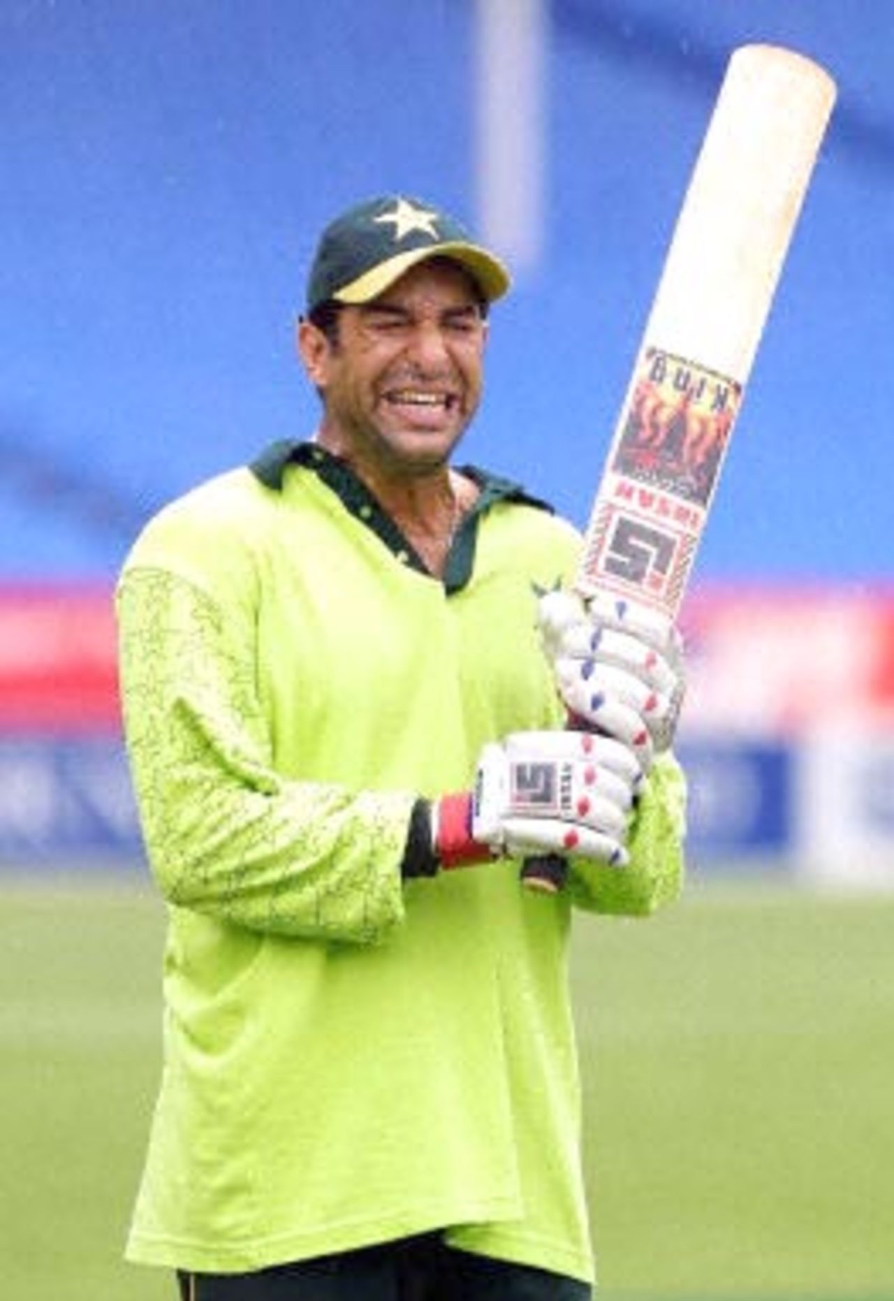 Pakistani cricket player Wasim Akram grimaces as the rain gets heavier during a light training session for the Pakistan cricket team at Eden Park in Auckland 16 February 2001. Pakistan will play New Zealand's Black Caps in the first of five one-day internationals starting 17 February.