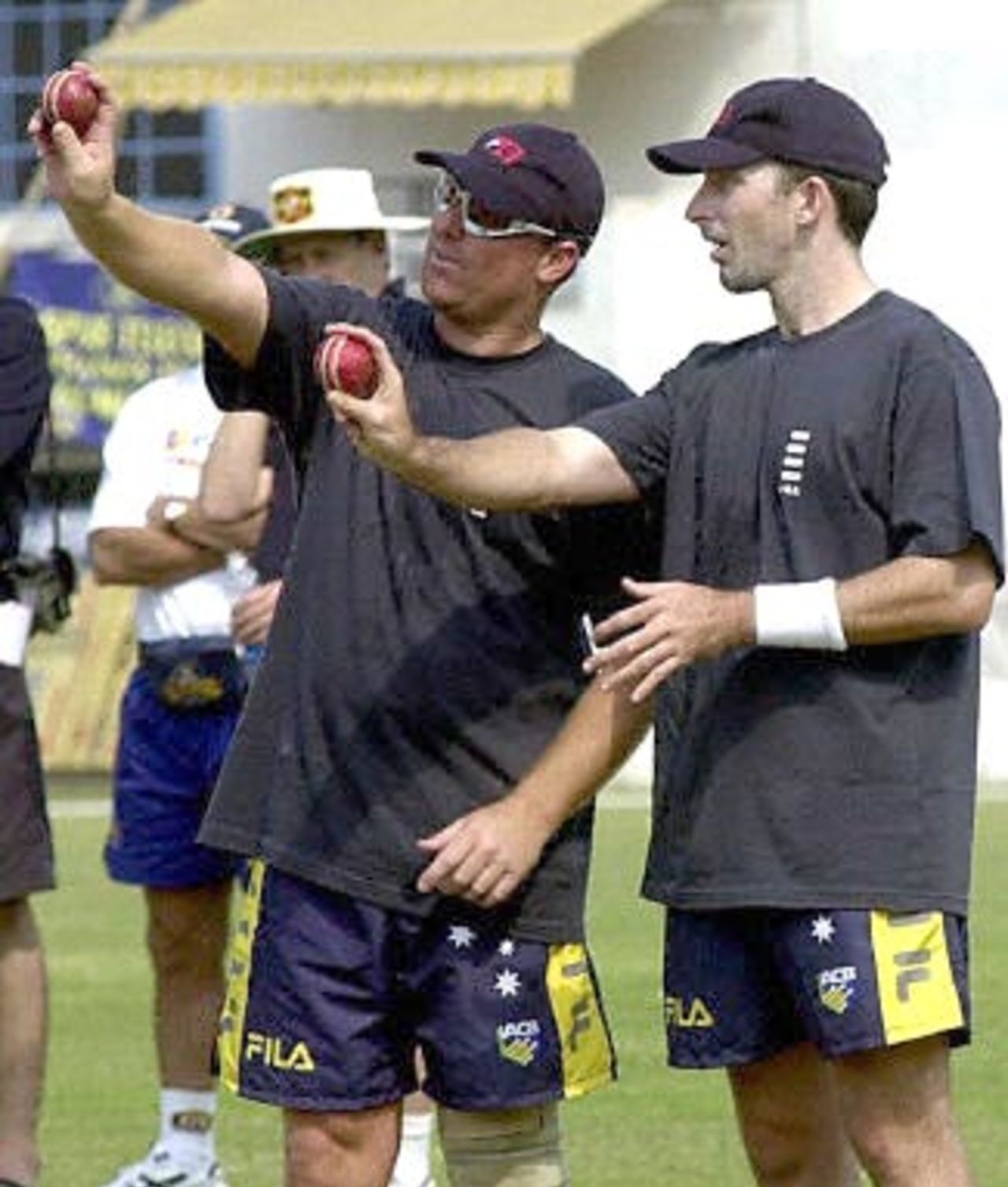Australian fast bowler D Fleming (R) and spin bowler Shane Warne look at balls during their net practice session at the Nagpur stadium 16 February 2001. The Australian cricket team will play their first test match against India A, 17 February.
