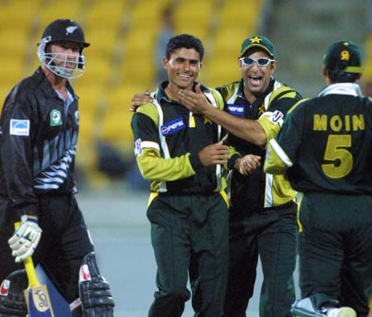 New Zealand batsman Chris Harris walks off the field after umpire Dave Quested adjudged him out leg before wicket off the bowling of Pakistan fast medium bowler Abdur Razzaq for 11. Razzaq is congratulated by team-mates Wasim Akram and Moin Khan. 3rd One-Day International: New Zealand v Pakistan at WestpacTrust Stadium, Wellington, 22 February 2001.