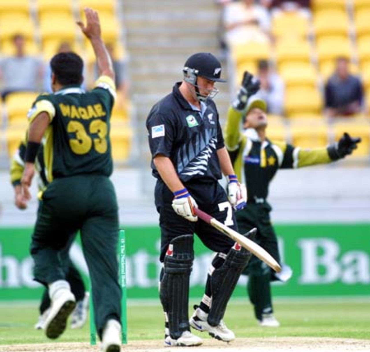Pakistan opening bowler Waqar Younis charges down the wicket in celebration of dismissing New Zealand batsman Roger Twose caught behind by wicket-keeper Moin Khan (throwing the ball in the air in the background) for one. 3rd One-Day International: New Zealand v Pakistan at WestpacTrust Stadium, Wellington, 22 February 2001.