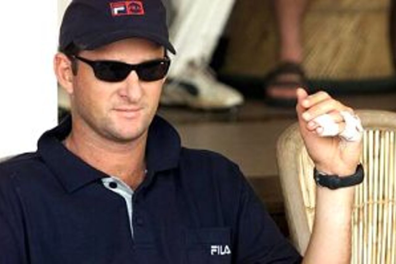 Mark Waugh of Australia sits in the player viewing area with an injured hand, after splitting the webbing between his fingers the previous day while attempting a catch, during day two of the three day tour match between Mumbai and Australia at Brabourne Stadium, Mumbai, India.