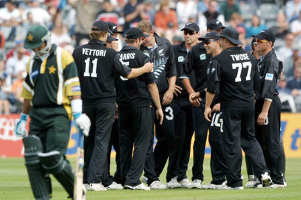 Pakistan batsman Saleem Elahi walks off the field after being dismissed by New Zealand medium fast bowler Jacob Oram, caught by Chris Harris at backward point for 13. Members of the New Zealand team gather to congratulate Oram. From left, Daniel Vettori, Nathan Astle (obscured), James Franklin (obscured), Chris Harris, Oram, Stephen Fleming, Daryl Tuffey (obscured), Craig McMillan, Roger Twose, Adam Parore (obscured) and Lou Vincent. 4th One-Day International: New Zealand v Pakistan at Jade Stadium, Christchurch, 25 February 2001.