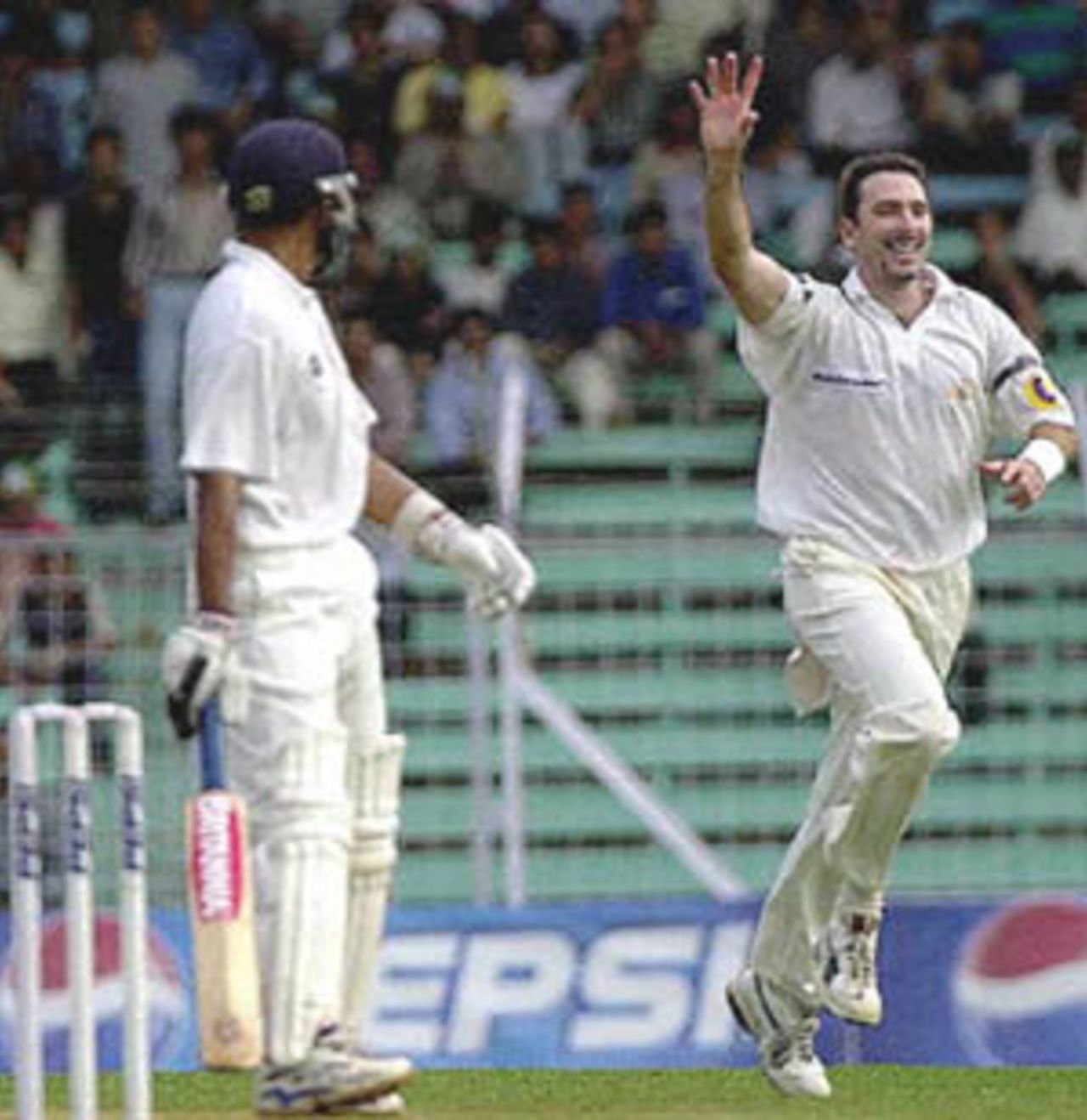 Australian pace bowler Damien Fleming (R) celebrates after claiming the wicket of Indian batsman Rahul Dravid (L) on the first day of the first test match between Indian and Australia at Wankhade stadium in Bombay 27 February 2001. Fleming got Dravid cuaght beind at 9 runs as India were struggling at 62 for 4 at lunch.