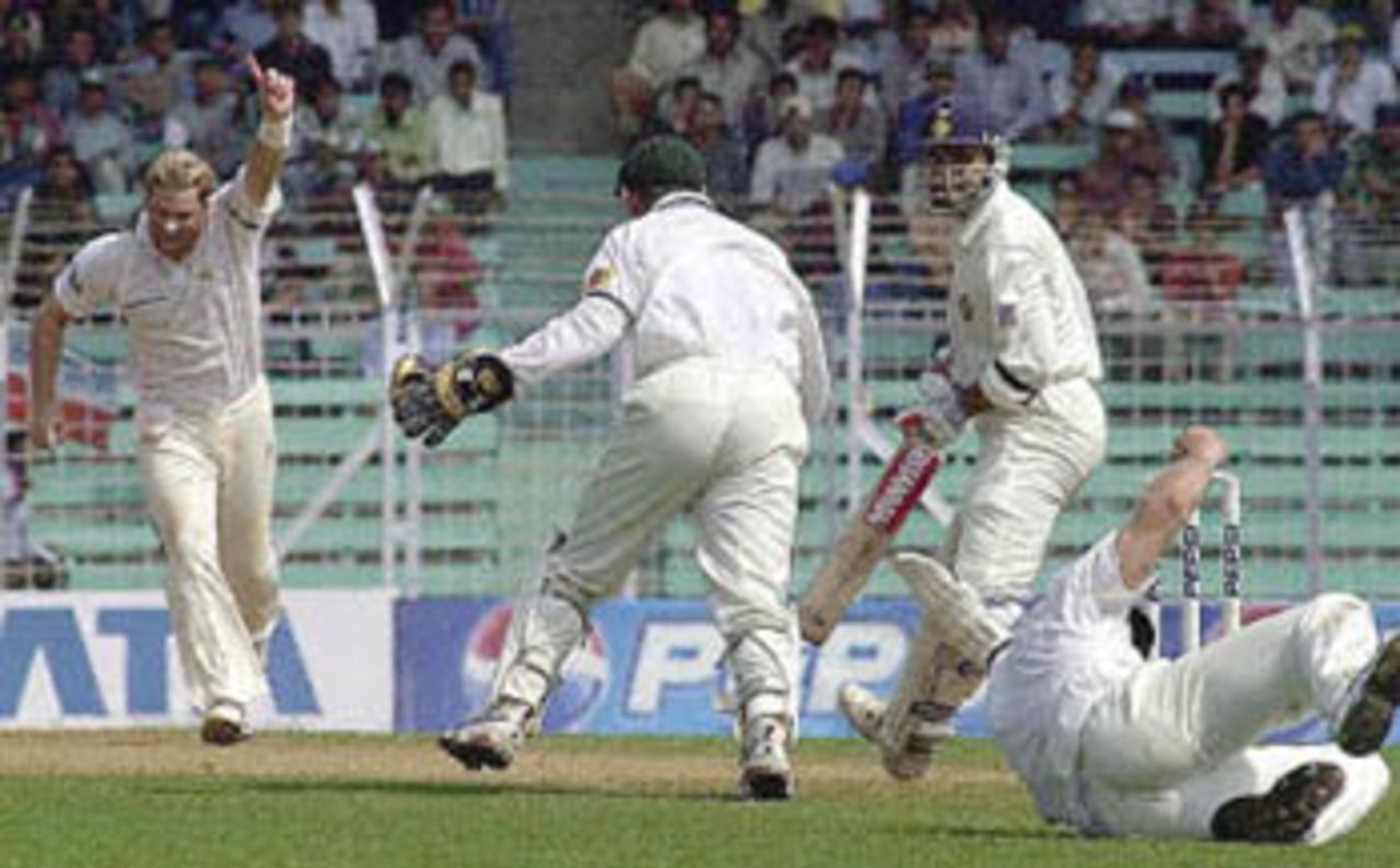 Australian spinner Shane Warne (L) celebrates after Indian captain Sourav Ganguly (2nd R) is out caught by Australian wicketkeeper Adam Gilchrist (2nd L) on the first day of the opening Test match between India and Australia at Wankahde stadium in Bombay, 27 February 2001. India were 110 for 4 after lunch after being limited to 62-4 by lunch by the tourists. Player at far R is unidentified.