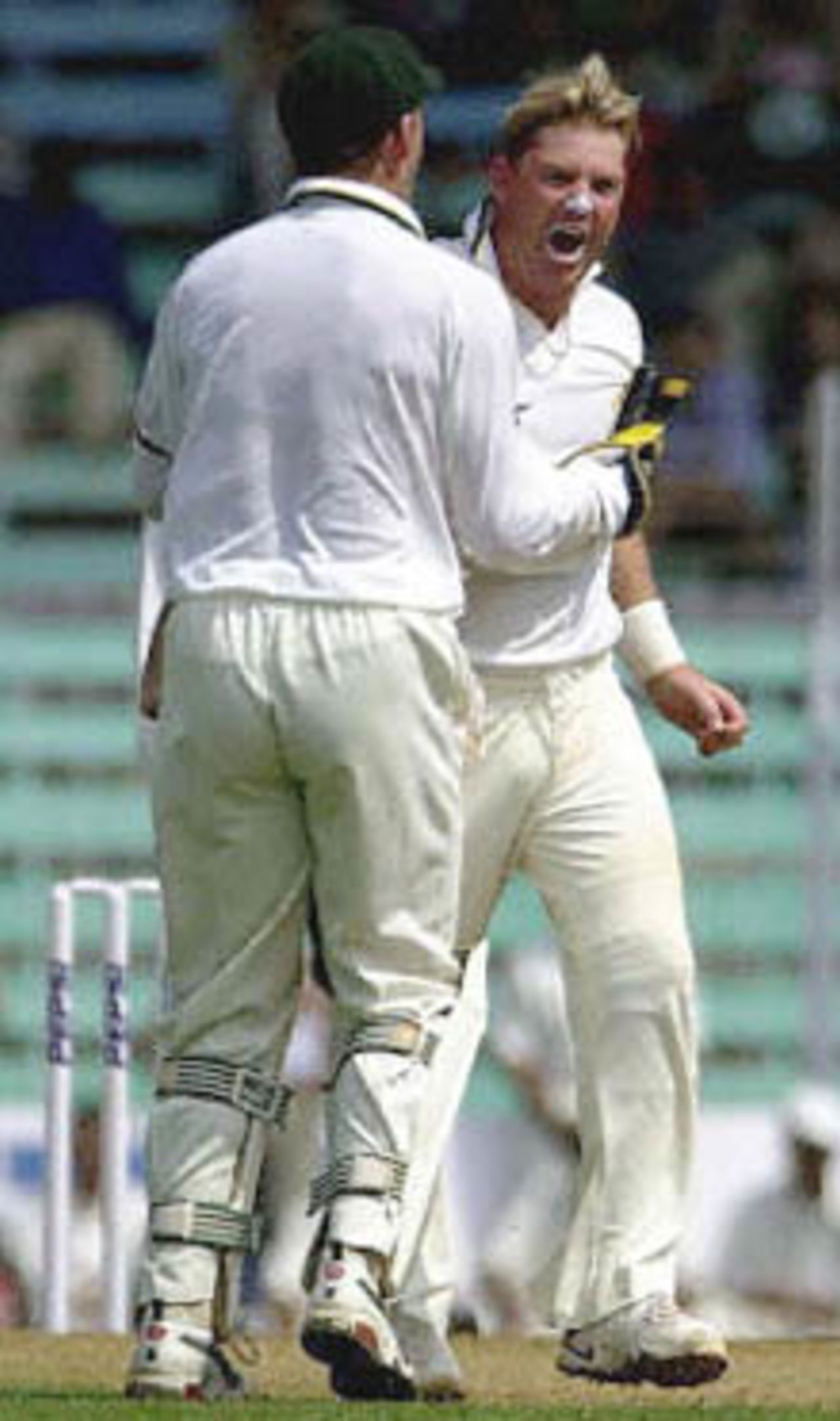 Australia's ace leg spinner Shane Warne (R) shouts after taking Indian captain Sourav Ganguly's wicket as he is cogratulated by Australian wicket keeper Adam Gilchrist on the first day of the first test match between India and Australia in Wankhade stadium in Bombay 27 February 2001. Warne took three wickets as India struggled at 165 for 8 wickets after tea.